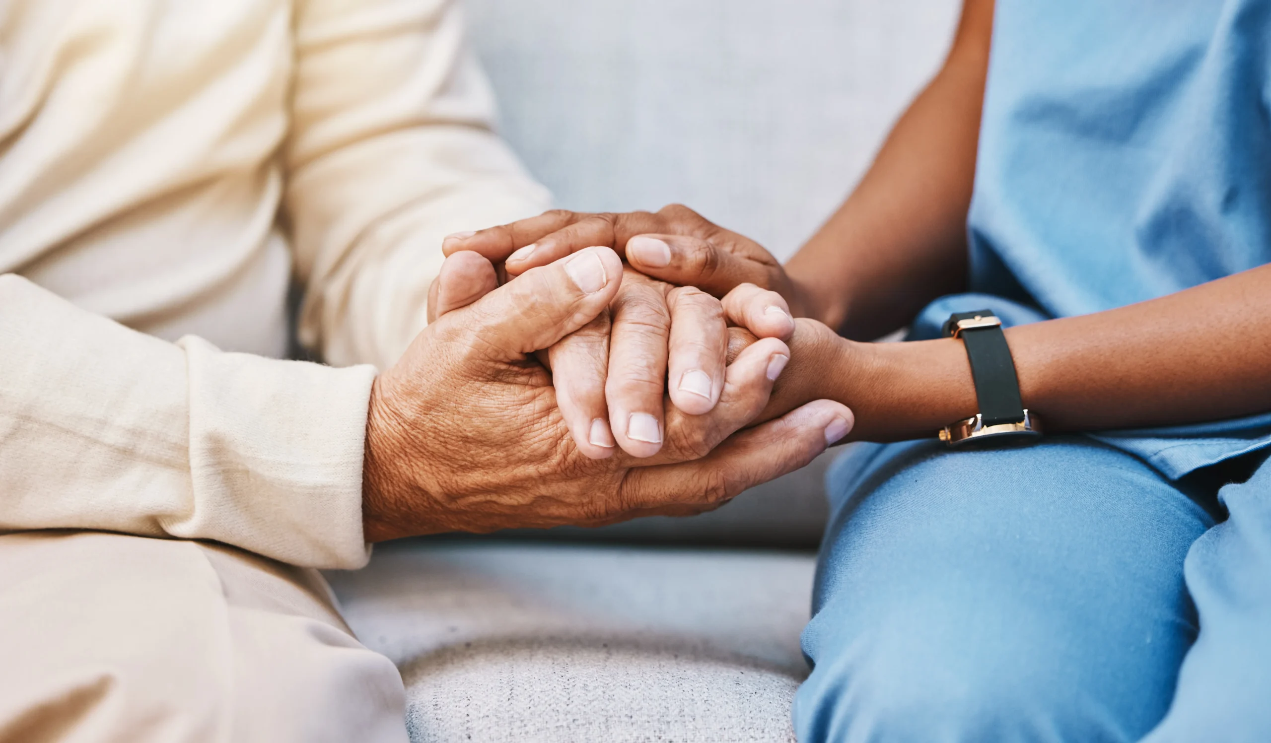 Nurse holding the hands of an elderly patient